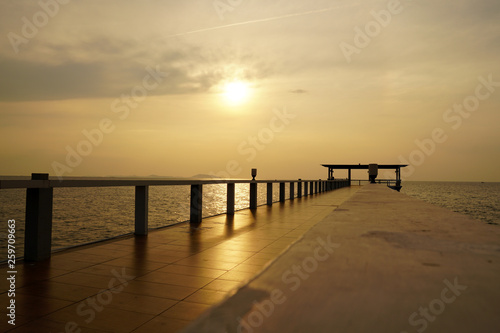 Wooded bridge in the port along sunrise at island beach.