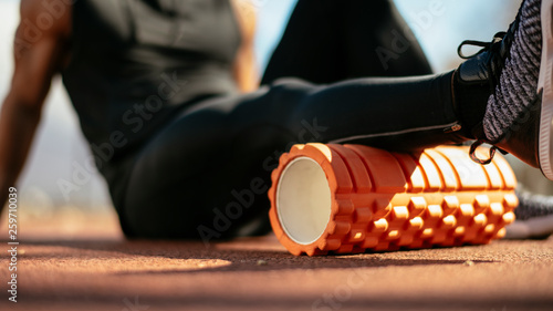Fotografie Man foam rolling. Athlete stretches using foam roller.