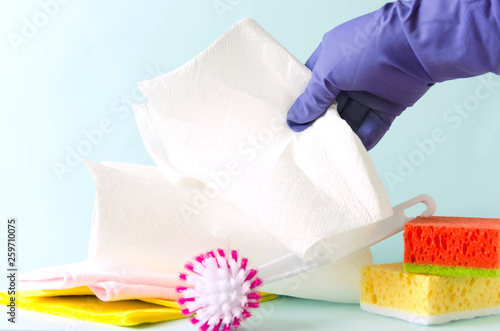 Paper towels rool and different cleaning items, cleaning lady taking paper towel for wiping dust.Concept of cleaning process