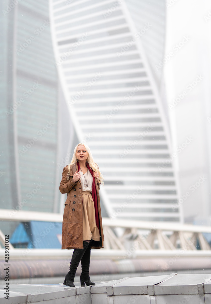 Beautiful young girl on the background of skyscrapers