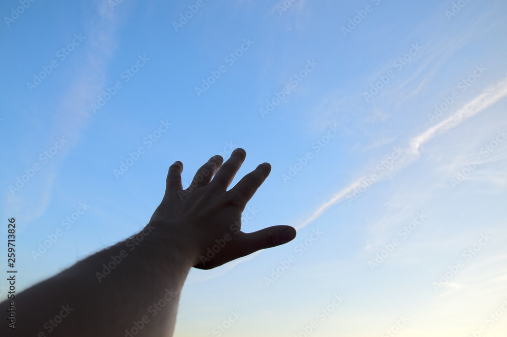 hand stretching to the blue clear sky hand stretching to the blue clear sky