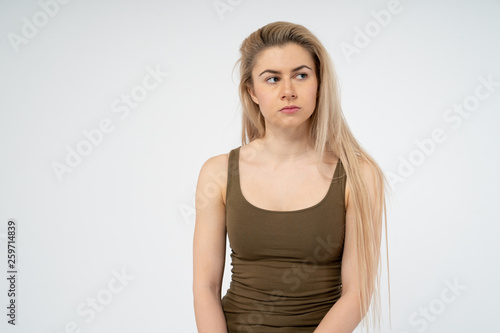 Young attractive girl seriously looking away. Isolated on white background
