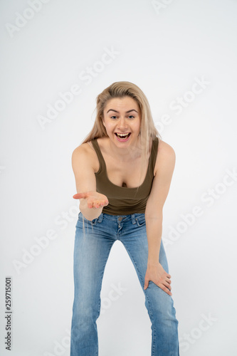 Young attractive girl laughs and shows her hand to the camera. Isolated on white background