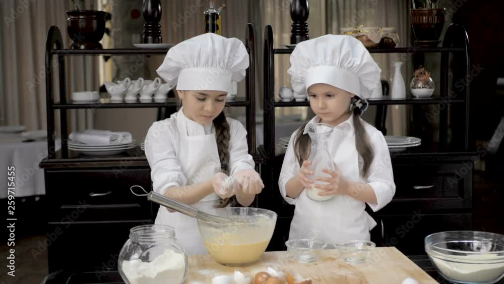 Funny young girls are preparing the dough in the kitchen Funny young girls are preparing the dough in the kitchen