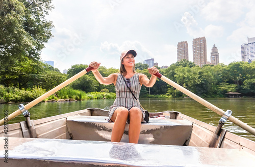 Obraz na plátně Woman rowing a rowboat and having fun in nature