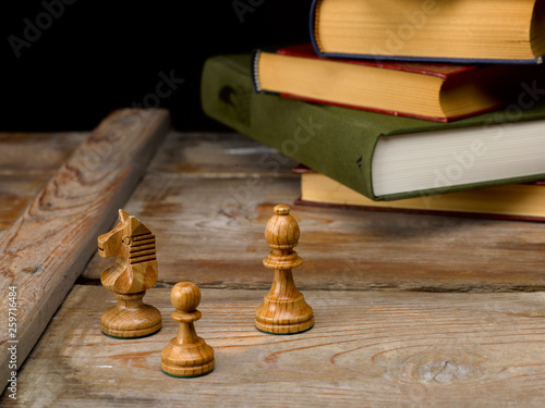 Bodegón figuras de ajedrez con libros y fondo de madera