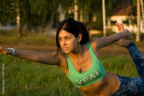 Young woman doing yoga in evening park