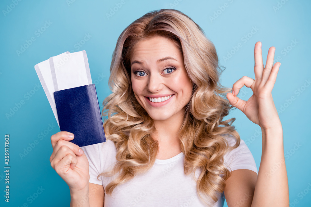 Close-up portrait of her she nice-looking lovely sweet attractive cheerful optimistic wavy-haired lady holding in hand paper document boarding pass showing ok-sign isolated over blue pastel background