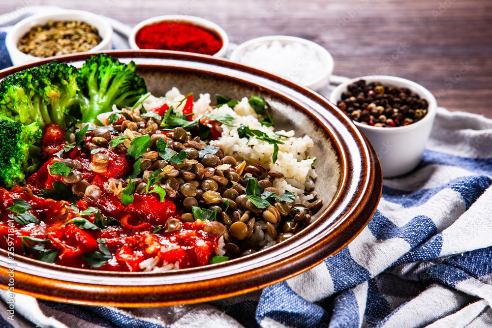 Rice with lentils and vegetables on wooden table Rice with lentils and vegetables on wooden table