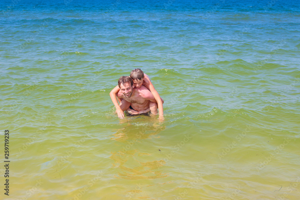 Father and son splashing in the sea