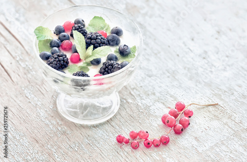 Summer light breakfast. Berries with yogurtmo and simple flowers. Vintage style.