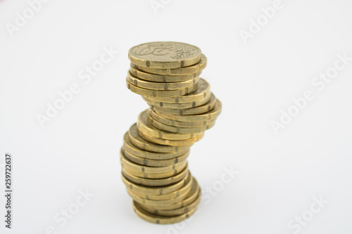 Unstable economy. Stack twenty euro cent coins on white background. Savings.