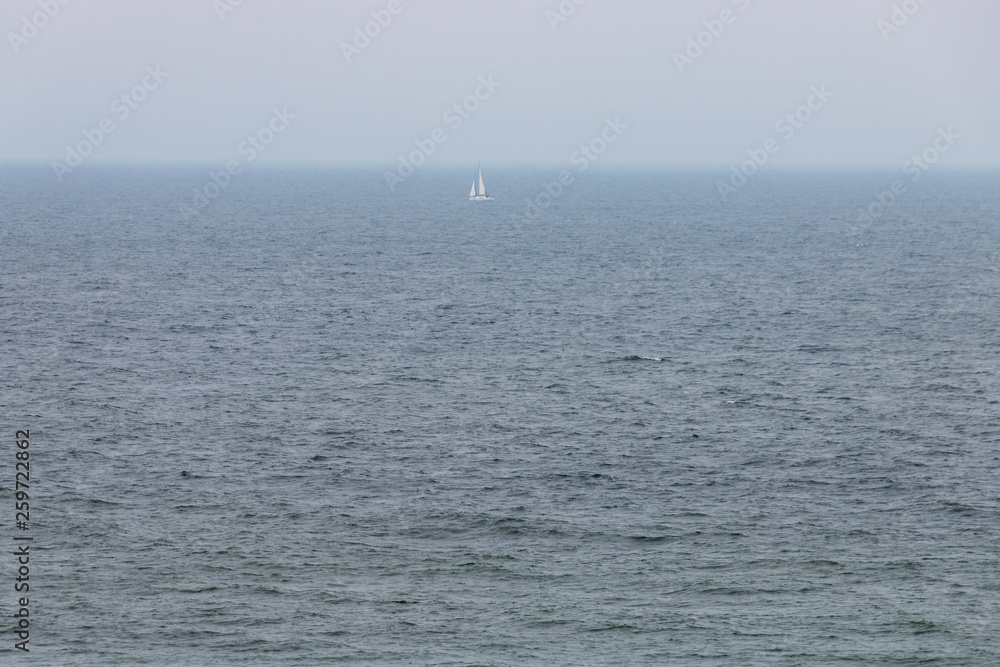 Seascape on a cloudy day with a small single boat