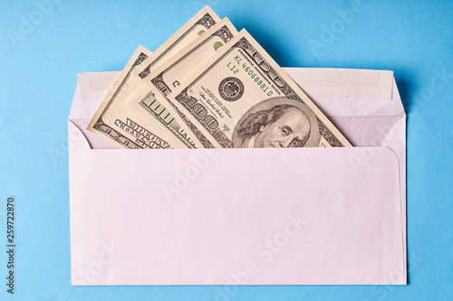 American dollars in a white envelope. Blue background