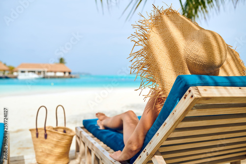 Photo Woman at beach on wooden sun bed loungers