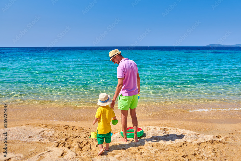 Toddler boy on beach with father Toddler boy on beach with father