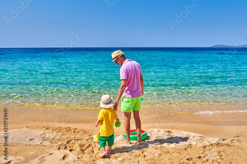Toddler boy on beach with father