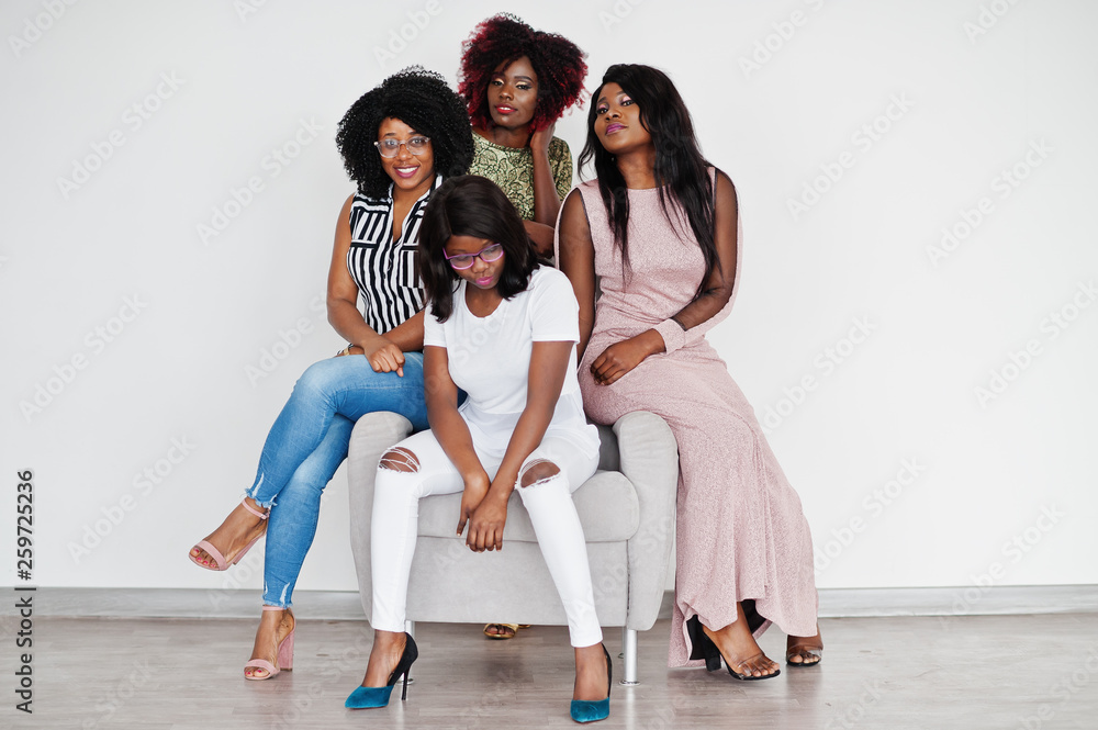 Happy brightful positive moments of four african girls. Having fun and smiling on chair against white empty wall. Lovely moments of four best friends. Happy brightful positive moments of four african girls. Having fun and smiling on chair against white empty wall. Lovely moments of four best friends.