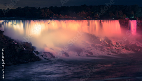 Niagara Falls at night seen from Canadian side, illuminated by colorful lights