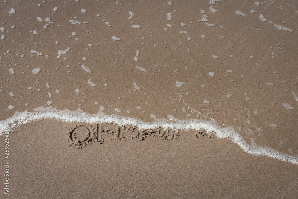 Fototapeta premium The word “offline” written in the sand symbolizing a time-out