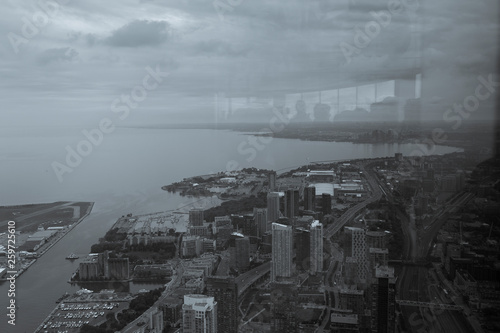 Toronto on a cloudy day  photography taken from CN Tower with reflection of people looking at the city