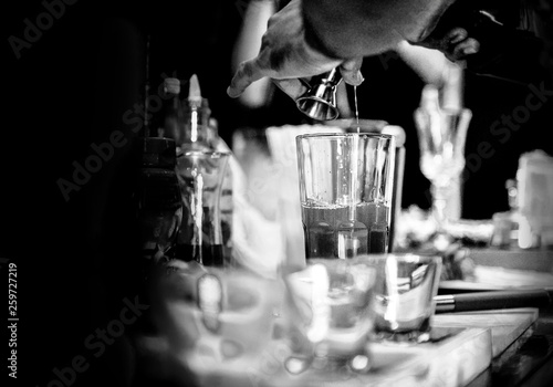 Obraz na plátne Bartender making alcohol cocktail at bar counter at nightclub, barman is making