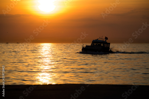 Sailing boat in calm wind during striking sunset
