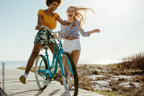 Cheerful girls having fun with a cycle