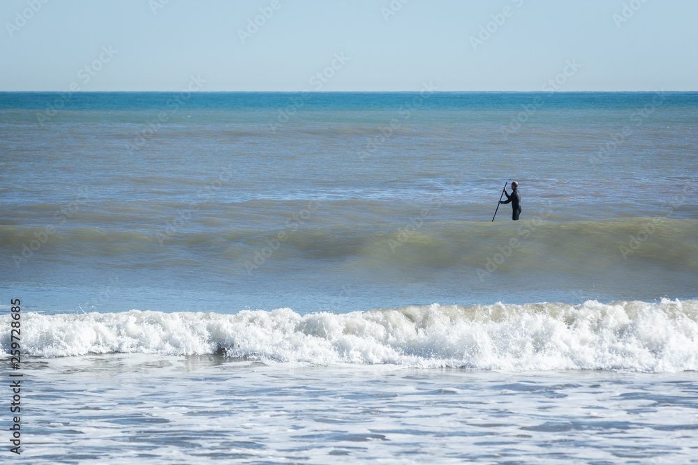 Surfer with paddle board catching the wave Surfer with paddle board catching the wave