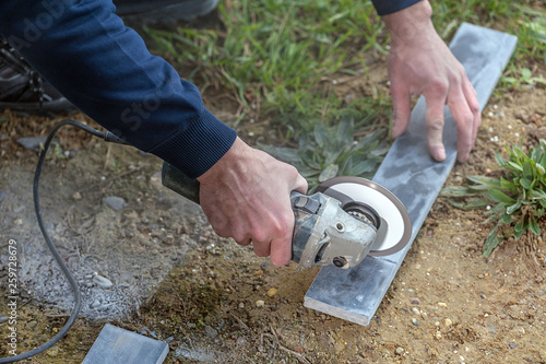 Tiler cutting a stone tile using an angle grinder
