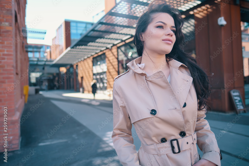 Woman in a business suit posing on the streets. Young beautiful woman in a business suit and coat posing on the streets. Toning