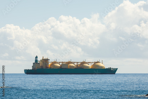 liquefied natural gas LNG transportation tanker ship, blue sea and sunny sky backgound photo