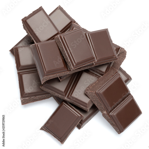 Dark organic chocolate pieces isolated on white background