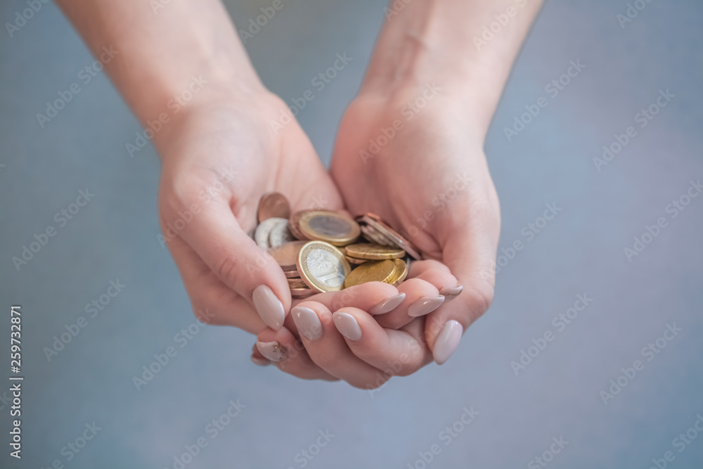 a handful of coins on a gray background, women's palms hold euro, a lot of money, economical expenses a handful of coins on a gray background, women's palms hold euro, a lot of money, economical expenses