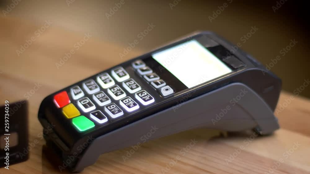 Closeup shoot of a payment terminal being used for payment by credit card in the store indoors