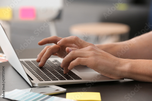 Male IT designer working in office, closeup