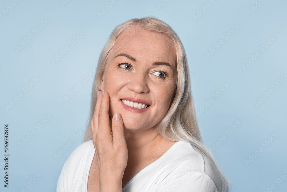 Mature woman with healthy skin on color background Mature woman with healthy skin on color background