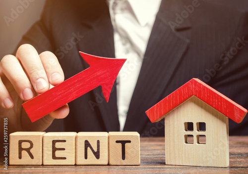 Wooden blocks with the word Rent, house and up arrow. The concept of the high cost of rent for an apartment or home. Interest rates are rising. Real estate market. Increased demand for rental property photo