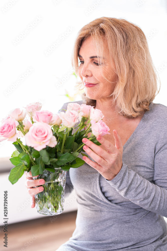 Attraktive ältere Frau mir einem Strauss Rosen 