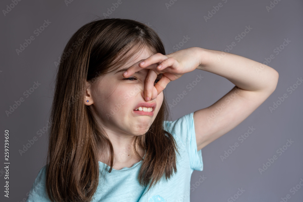 Young girl covering her nose with a bad smell Young girl covering her nose with a bad smell