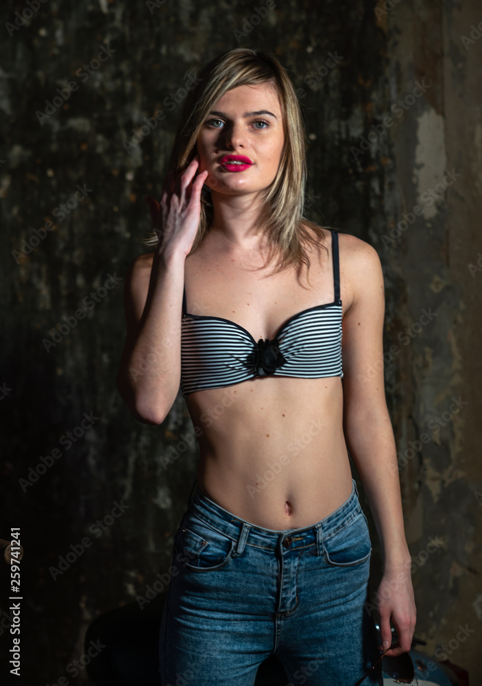 Fototapeta premium Beautiful young girl in bodice and jeans in the old studio