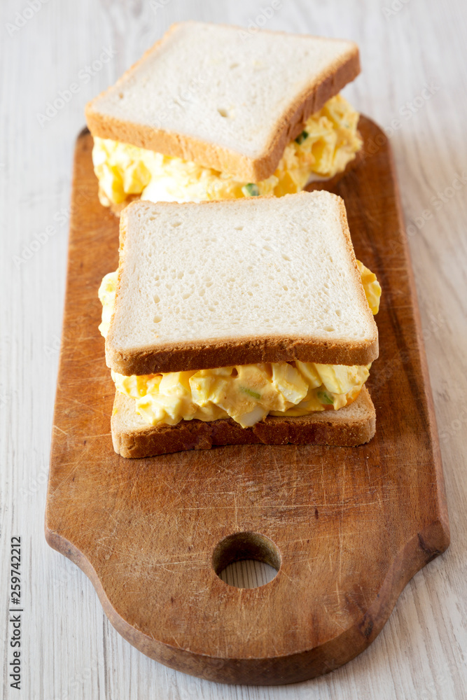 Homemade egg sandwich for breakfast over white wooden surface, low angle view. Close-up.