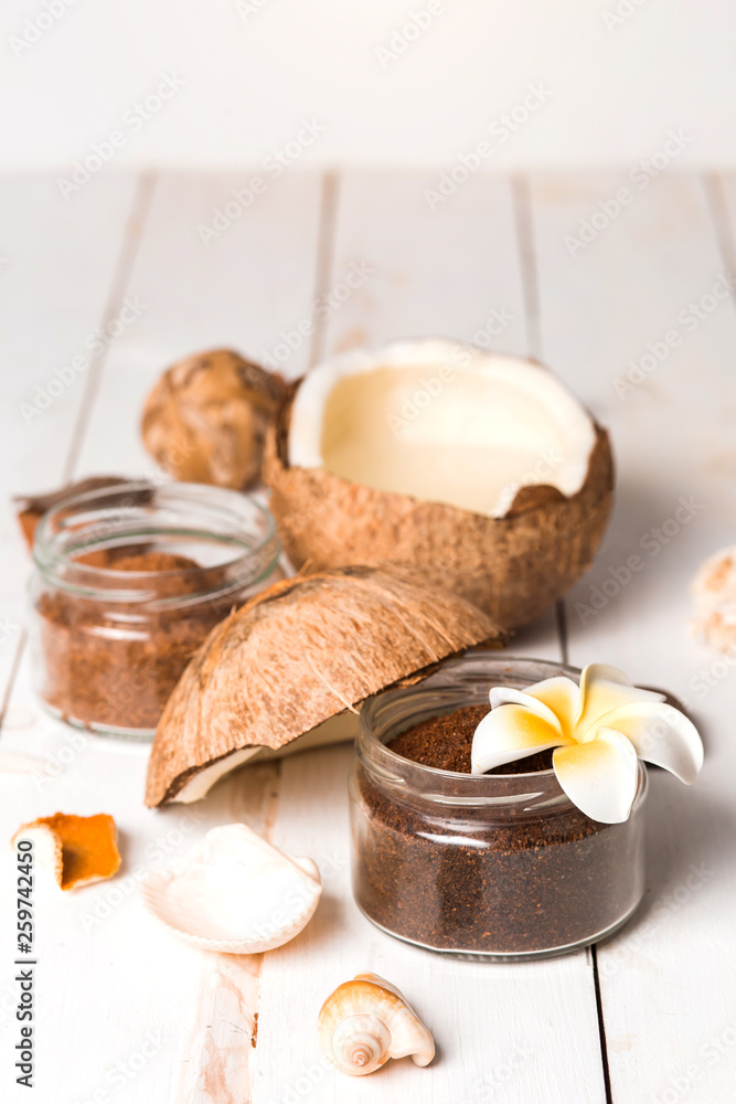 Coconut, spa products, coffee scrub and seashells on white background Coconut, spa products, coffee scrub and seashells on white background