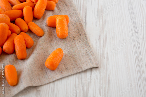 Tasty peeled baby carrots on cloth, side view. Copy space and text area.