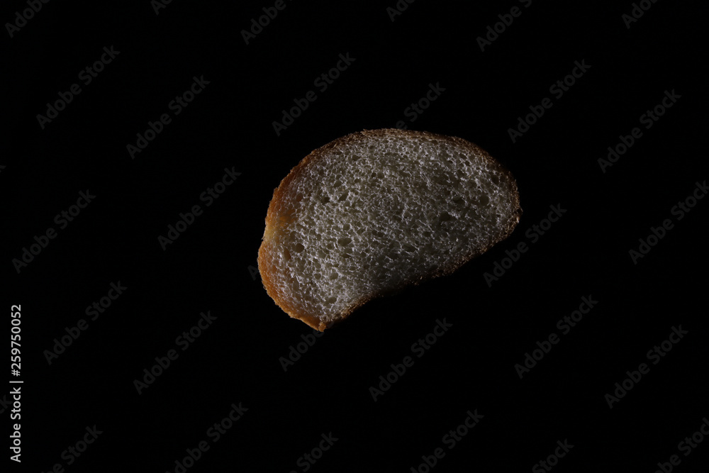 Piece of bread on black background Piece of bread on black background