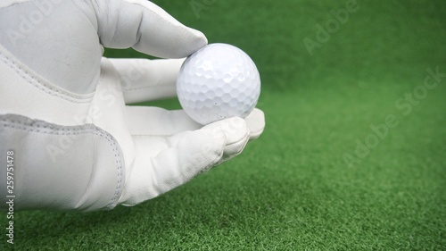 Golfer with glove holding a golf ball