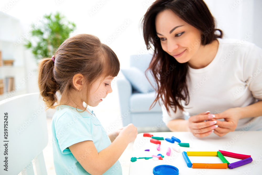 Mom and little daughter sculpt new house of plasticine. Child development and education. Family leisure with a child. Happy childhood Mom and little daughter sculpt new house of plasticine. Child development and education. Family leisure with a child. Happy childhood