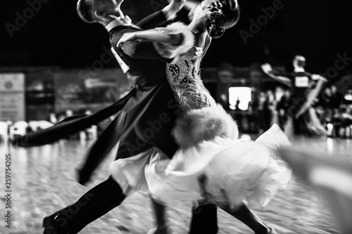 Obraz na plátně couple of dancers ballroom dancing blurred motion black-and-white photo
