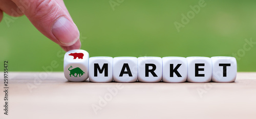 Symbol for a trend change at the stock market. Hand turns a dice and changes the symbol of a bear to a bull to indicate the change from the bear market to a bull market.