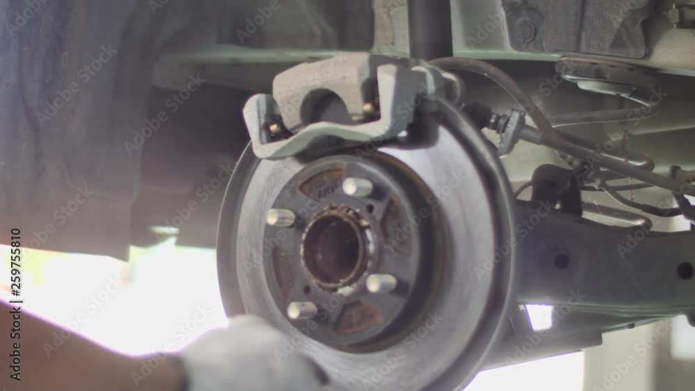 Auto mechanic working on brakes in a car repair shop domestic garage. Professional repair of a car. Auto mechanic working on brakes in a car repair shop domestic garage. Professional repair of a car.